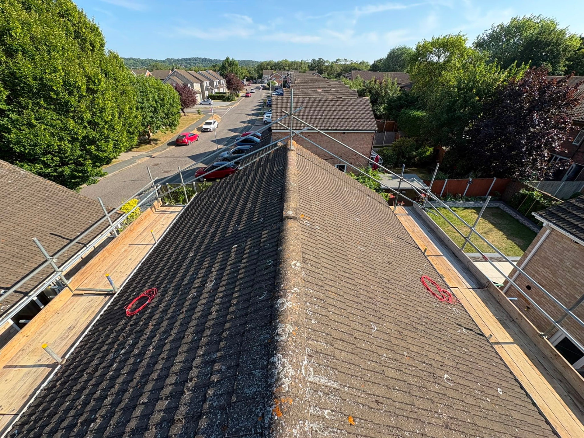 Roof scaffolding with boarded platforms and guardrails either side of a ridge